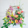 Colorful floral arrangement in a white container with roses and lilies