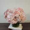 Pink bouquet with roses, hydrangeas, and orchids in a glass vase