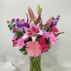 Pink and purple mixed bouquet in a clear glass vase