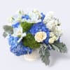 Blue and white floral arrangement in a white vase