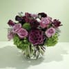 Pink and purple rose arrangement in a striped glass vase