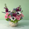 Pink and white floral arrangement in a polka-dot ceramic pot