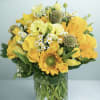 Yellow bouquet with roses, sunflowers, and small white daisies in a glass vase
