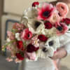 Handheld bouquet of pink, red, and white flowers