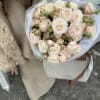 Bouquet of pale pink and white roses wrapped in white paper