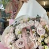 Bouquet of pale pink roses and white flowers wrapped in pink paper