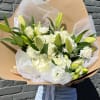 Large bouquet of white lilies and carnations wrapped in kraft paper