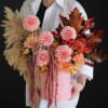 Pink and peach floral arrangement in a round pink box