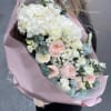 Large bouquet of white and blush flowers wrapped in pink paper