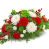 Red and white floral arrangement with berries and greenery