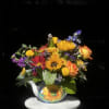 Bright mixed bouquet in a painted ceramic pitcher