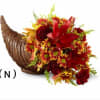 Cornucopia arrangement of red and yellow flowers in a woven horn basket