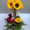 Sunflowers and red roses arranged in a metal bucket