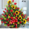 Large arrangement of red roses and sunflowers with a red ribbon bow