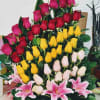 Basket arrangement of roses and pink lilies in red, yellow, and white