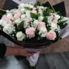Bouquet of pale pink and white roses wrapped in black paper