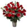 Bouquet of red roses with baby's breath in a clear glass vase