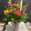 Mixed bouquet in a glass vase with pink, coral, and yellow blooms