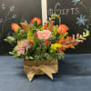 Mixed bouquet in a wooden box with orange roses and pink gerbera daisies