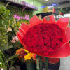 Large bouquet of red roses wrapped in red paper