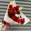 Bouquet of red roses and red carnations wrapped in white paper