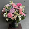 Pink and white mixed flower arrangement in a dark vase