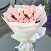 Bouquet of pale pink roses wrapped in white paper