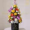 Tall mixed flower arrangement in a black cylindrical box