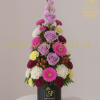 Tiered bouquet of lavender roses, pink gerberas, and mixed daisies in a black box