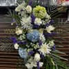 Standing floral spray with white, blue, and purple flowers
