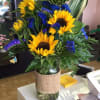 Sunflowers with a splash of purple in tall cylinder vase