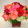 Roses and tulips in a square vase accented with a hydrangea gives