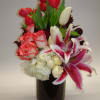 A pave&#039; style arrangement with tulips, roses, stargazer lilies, hydrangea complement each