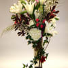 Stunning white lilies, roses and hydrangea standout against the dark leaves and