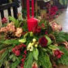 here is a beautiful vase of winter greens and flowers with touch