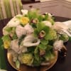 Low round centerpiece featering green, white and touches of yellow .perfecly balance