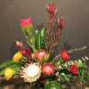 Exotic foliage accent tropical blossoms. This design requires special order flowers and