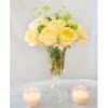 A bouquet of yellow roses in a tower glass vase