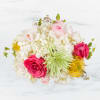 This arrangement includes cymbidium orchids, protea, hydrangea, roses, and other seasonal blooms.