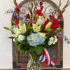 This medium arrangement has a collection of hydrangeas, lilies, and stock.