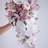 Magnificent white orchids cascading surrounded by roses, tulips, wax flower and more.