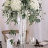 White Hydrangeas, stock, eucalyptus and more fill this tall and gorgeous table