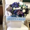 This Chocolato baby boy basket is made with purple hydrangeas, white and