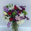 Fresh  floral arrangement with white lilies, lavender and purple stock, green