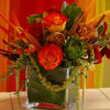 a mix of red-orange roses, heleconias, and amaranthus and cymbidium orchids.