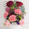 A fresh medley bowl of roses, carnations, and other flowers in a