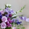 This arrangement with blooms in hues of lavender and plum is a