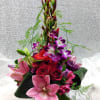 This extravagant arrangement contains red roses, pink lilies, orchids, and gladiolas. 