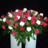Red and white roses are enhanced by carnations, eucalyptus, and miniature carnations