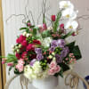 This Chocolato arrangement is made with phalaenopsis orchids, purple roses, spray roses